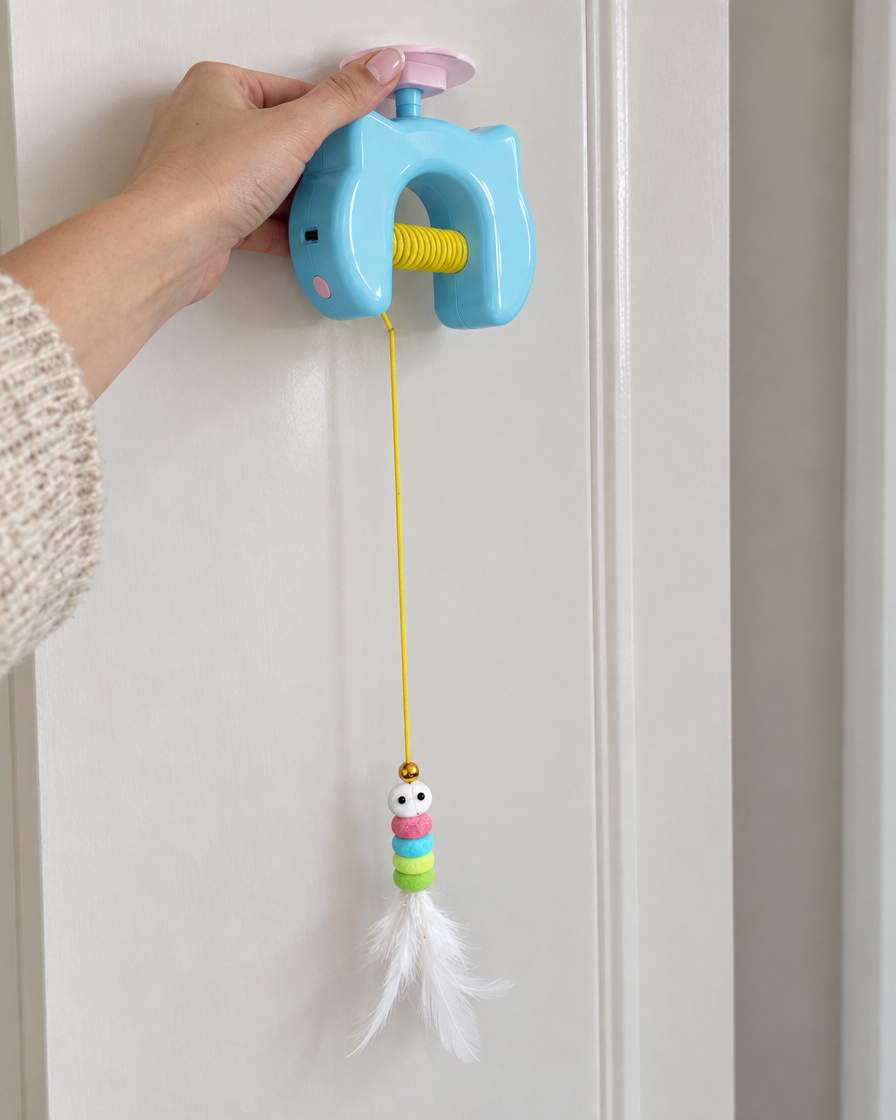Hand pressing the OvaPet toy's suction mount high on a door